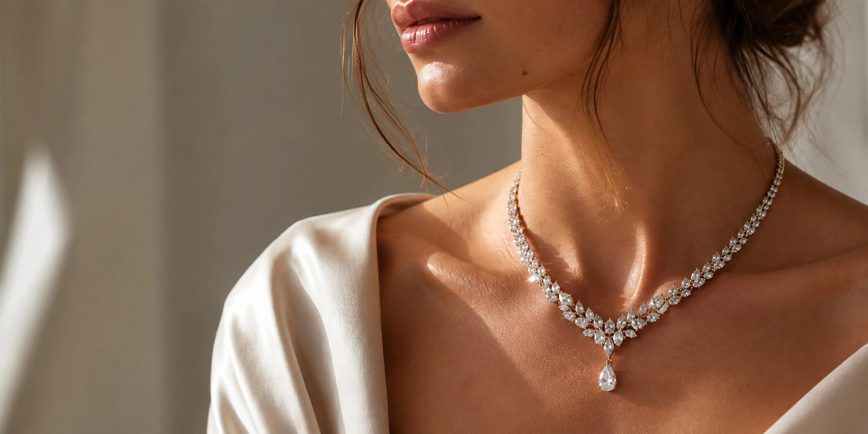 Woman wearing a bespoke Aquae Jewels marquise diamond necklace with pear-cut drop in solid 18K gold